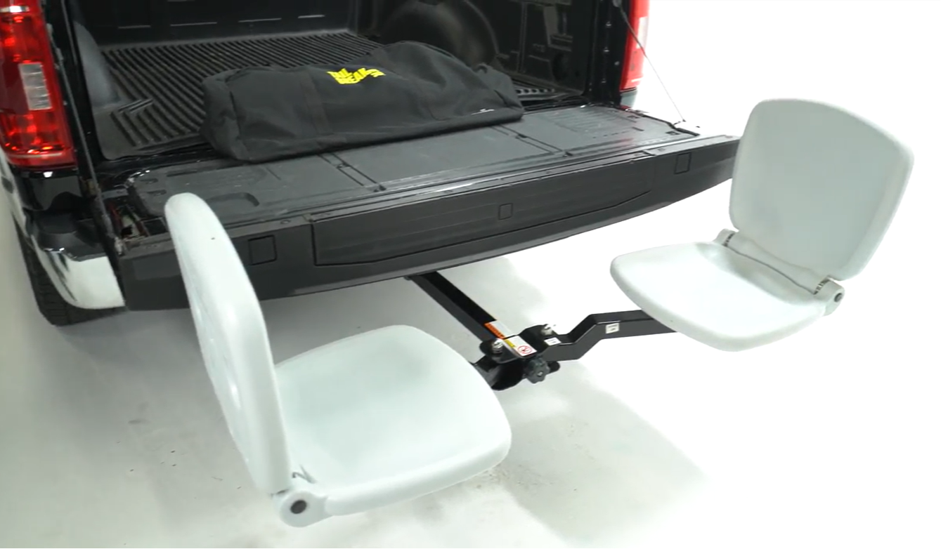 White folding chairs in a truck bed with a black bag on a white background