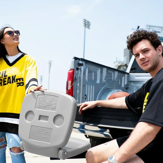 Two people with a 'Tail Breaker' product in front of an open truck bed.
