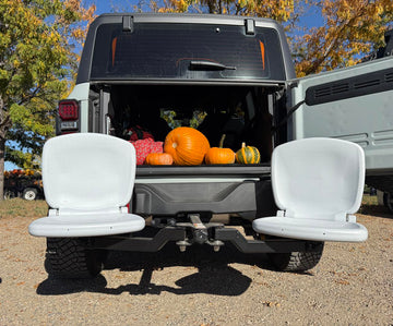 Tailbreaker seating system attached to an SUV with the tailgate open in a fall setting